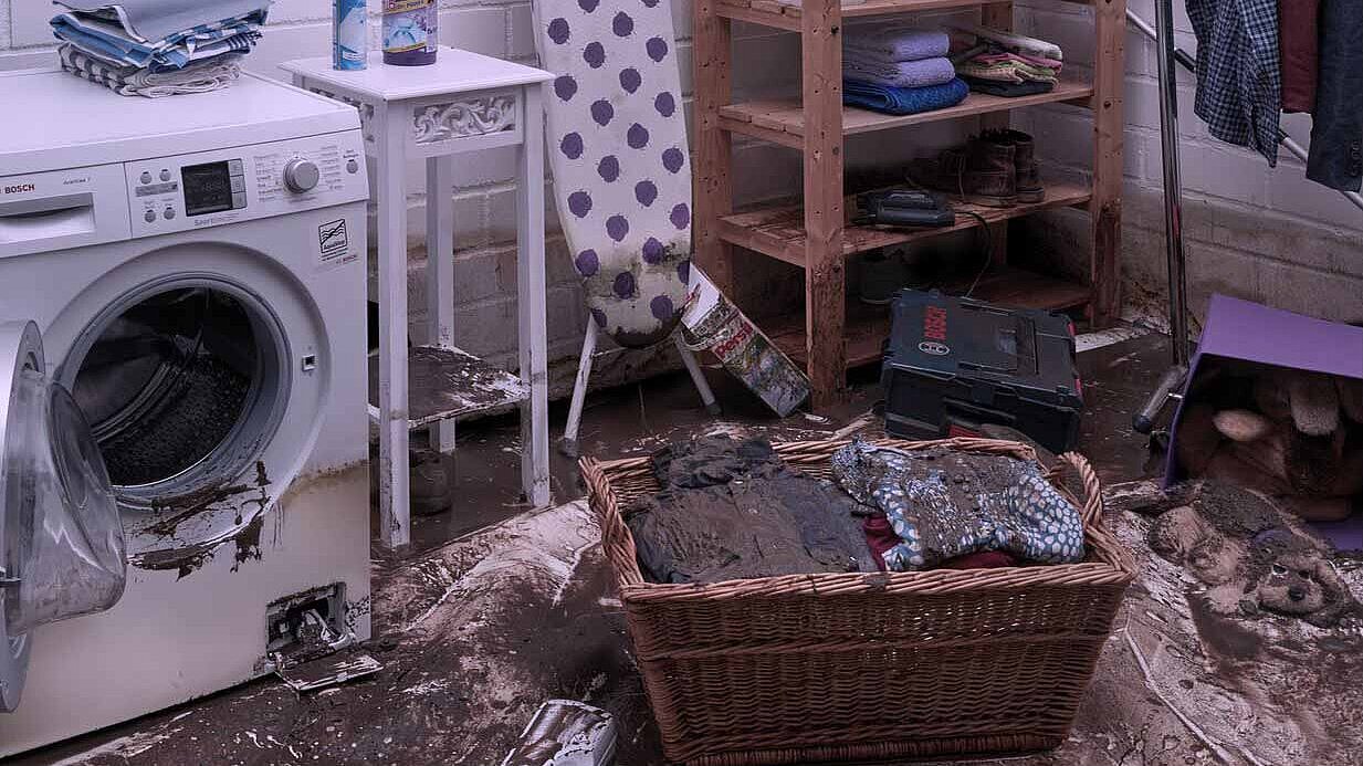 Uszkodzenie pralni Pralnia z brudnym koszem na bieliznę i pralką.